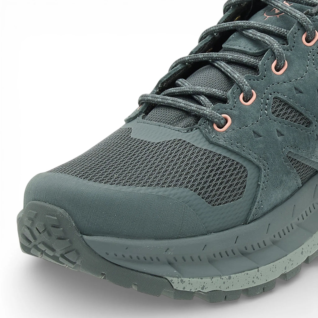 Green hiking boot with laces on a white background