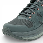 Green hiking boot with laces on a white background