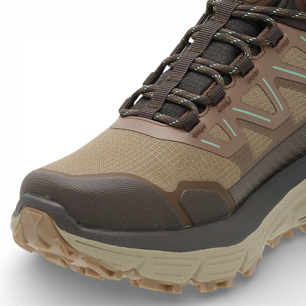 Brown hiking boot with a textured sole on a light gray background