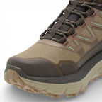 Brown hiking boot with a textured sole on a light gray background